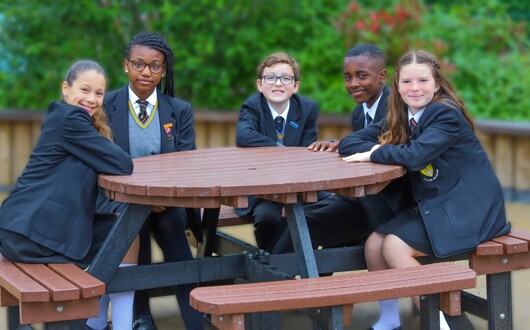 This is an image of 4 pupils sitting around a bench